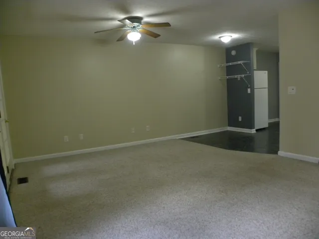 an empty room with closet and windows