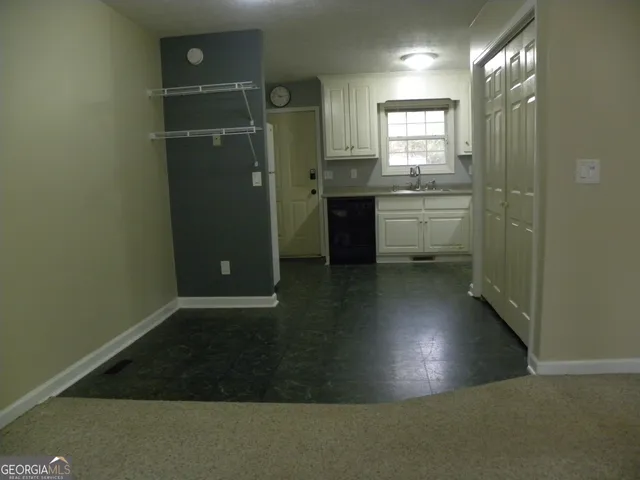 a kitchen with granite countertop white cabinets and white appliances