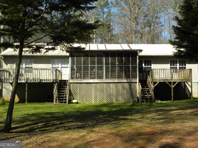 a view of a house with a yard and a large tree