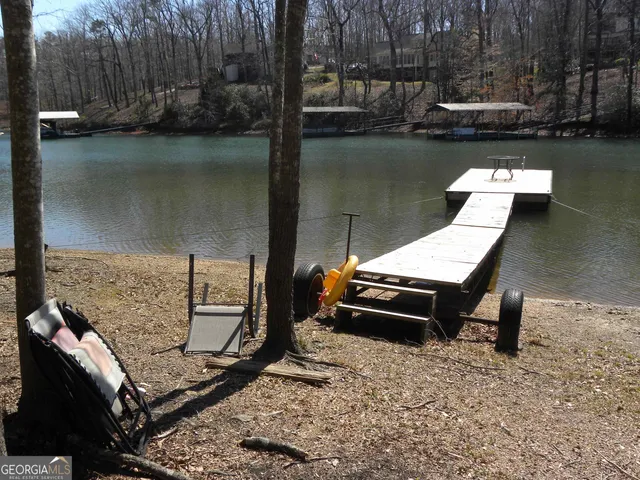 a view of a wooden chairs and table in the lake