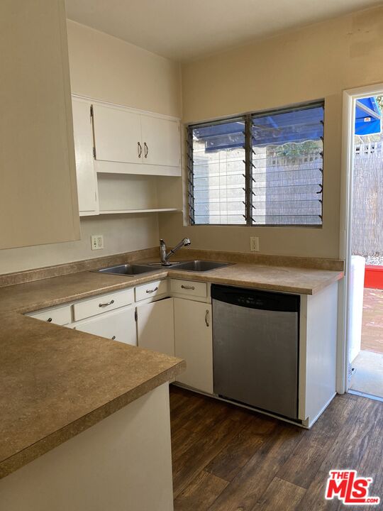 16464 Sunset Boulevard Pacific Palisades, CA 90272 - Photo 3 of 13 a kitchen with granite countertop a stove a sink and dishwasher with wooden floor