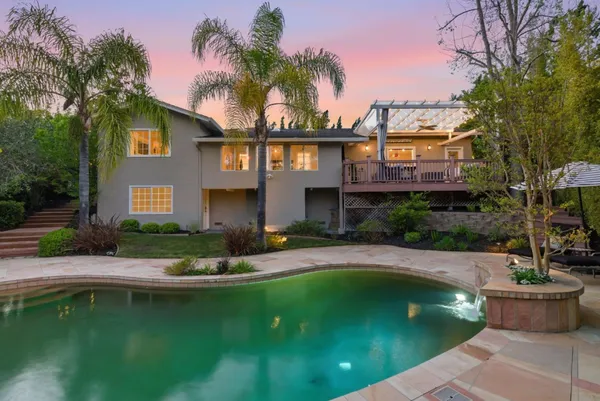 a front view of a house with swimming pool having outdoor seating