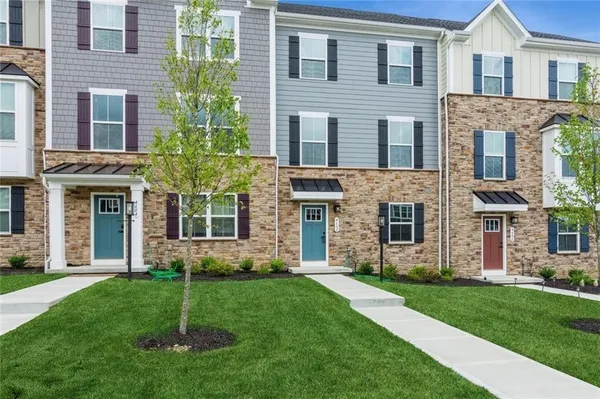 front view of a brick house with a yard