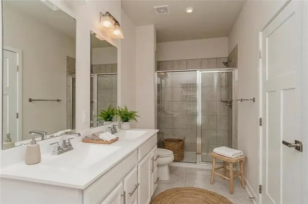 a bathroom with a sink toilet a mirror and shower