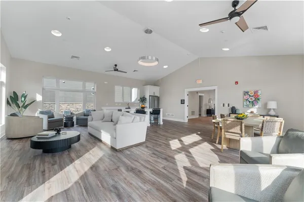 a living room with lots of furniture and view of kitchen