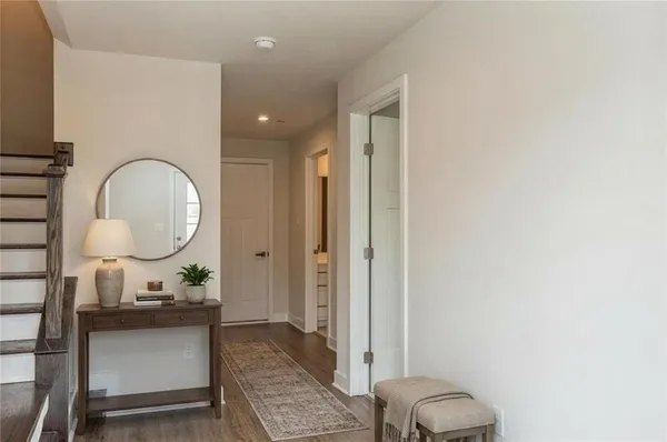 a living room with a mirror and a wooden floor