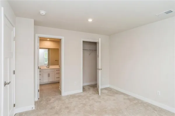 an empty room with a bathroom and mirror