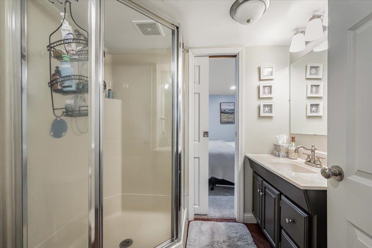 4426 Dodge Street Duluth, MN 55804 - Photo 18 of 27 Ensuite bathroom featuring visible vents, a stall shower, vanity, and ensuite bathroom