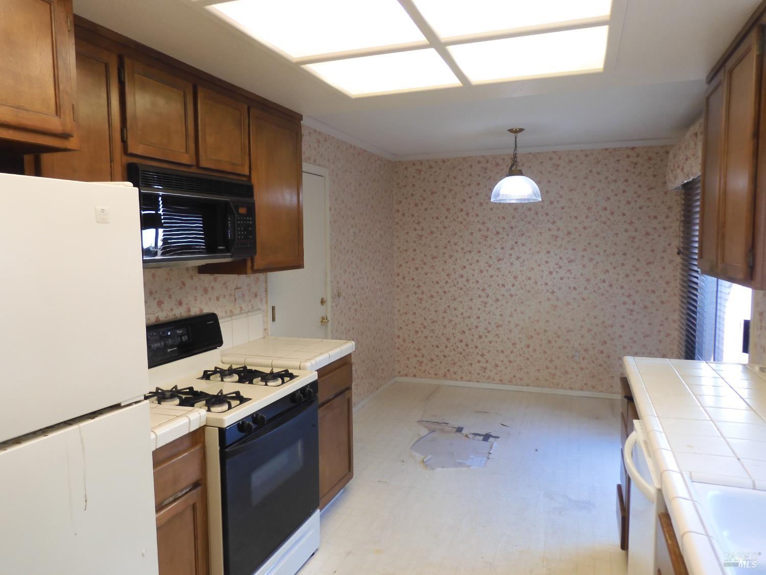 356 Singing Brook Circle Santa Rosa, CA 95409 - Photo 9 of 36 a kitchen with a stove a microwave and wooden cabinets