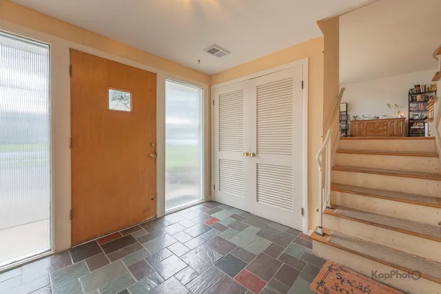 a view of a livingroom with entryway and stairs