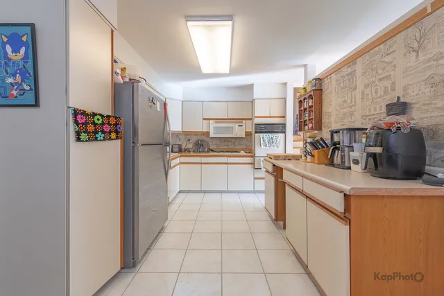 a kitchen with stainless steel appliances granite countertop a refrigerator and a stove top oven