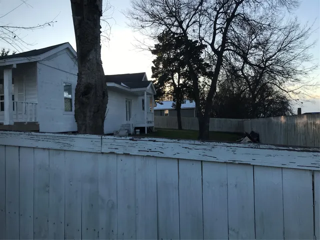 a view of a backyard with wooden fence