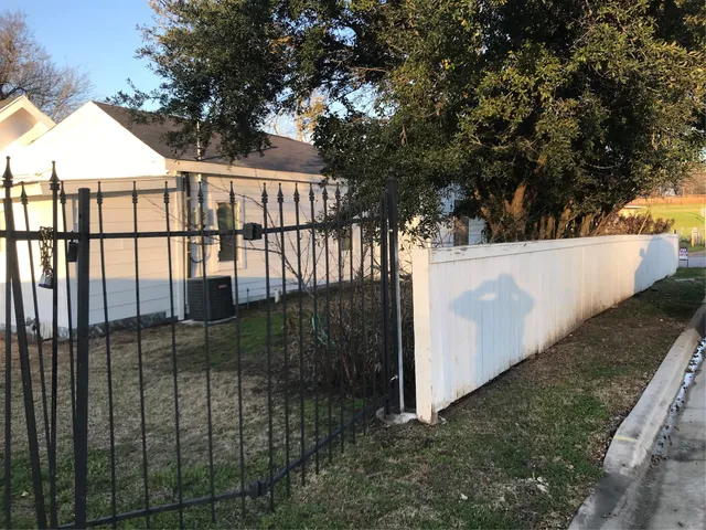 a view of a white house next to a yard and tree