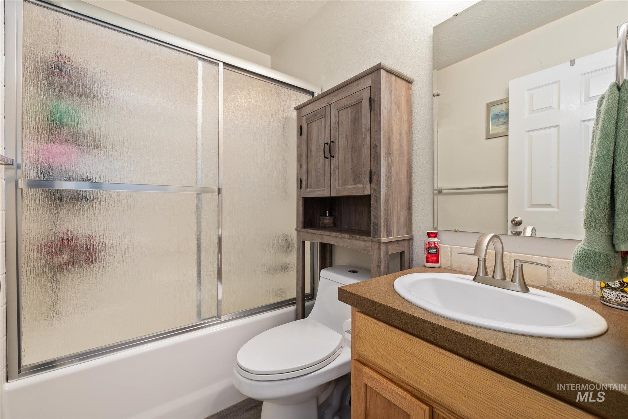 5401 Barkley Way Caldwell, ID 83607 - Photo 7 of 35 Bathroom featuring a built-in tub with a sliding frosted glass enclosure