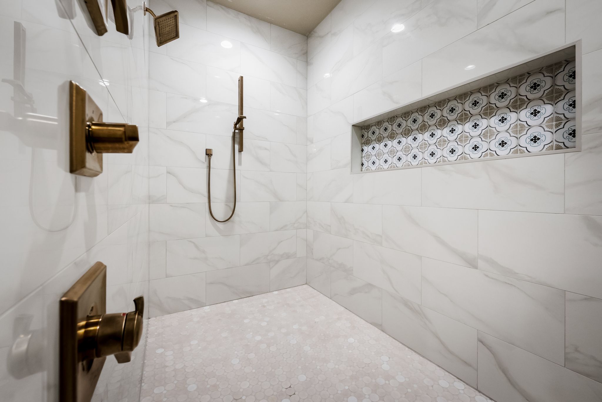 195 Desert Flower Spring Branch, TX 78070 - Photo 17 of 40 Spacious shower featuring large format white marble-look wall tiling, a decorative recessed niche with patterned tile, and a mosaic tiled floor