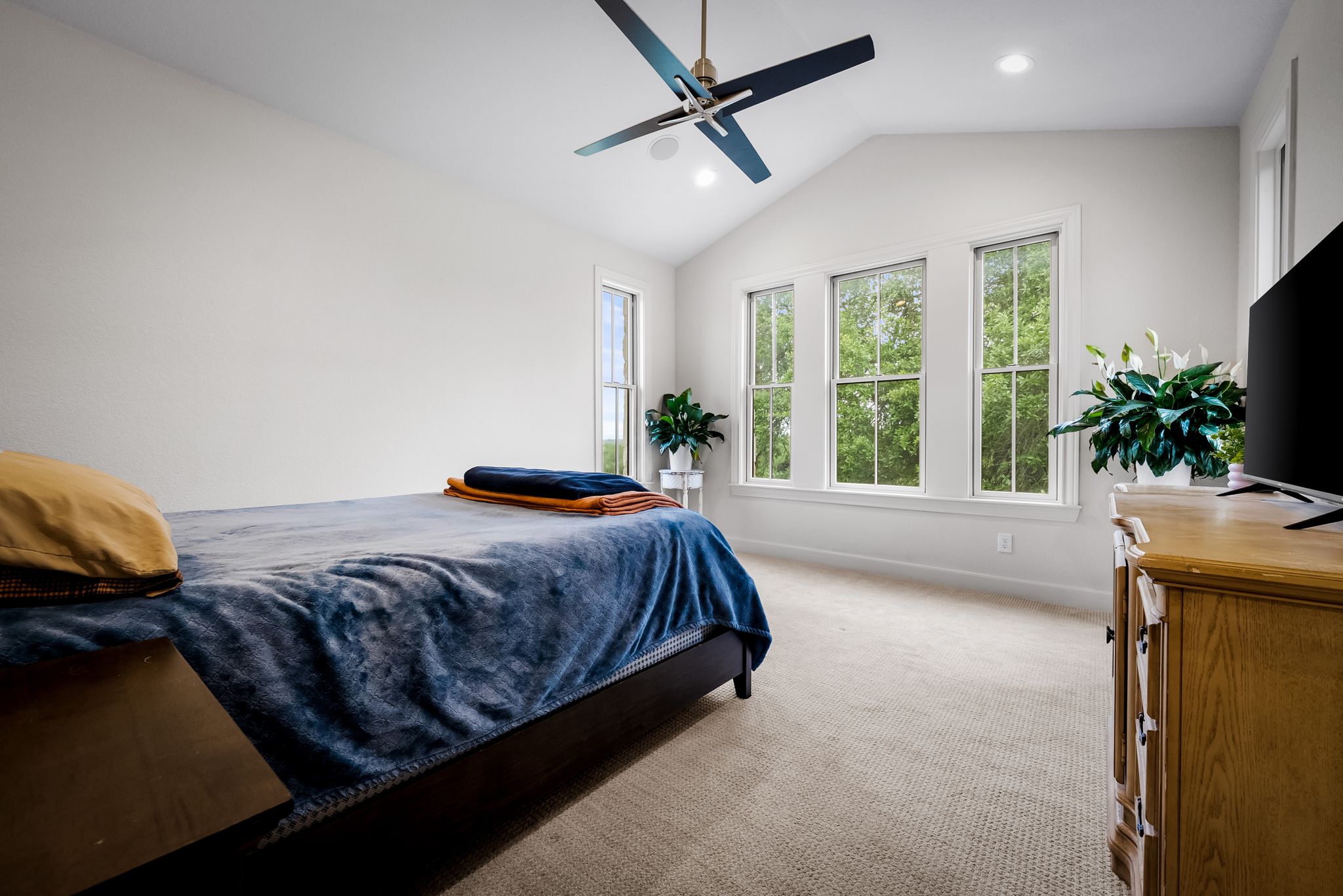 195 Desert Flower Spring Branch, TX 78070 - Photo 20 of 40 Vaulted ceiling room featuring a modern ceiling fan with integrated lighting, three large windows, recessed lighting, and light-toned carpeting