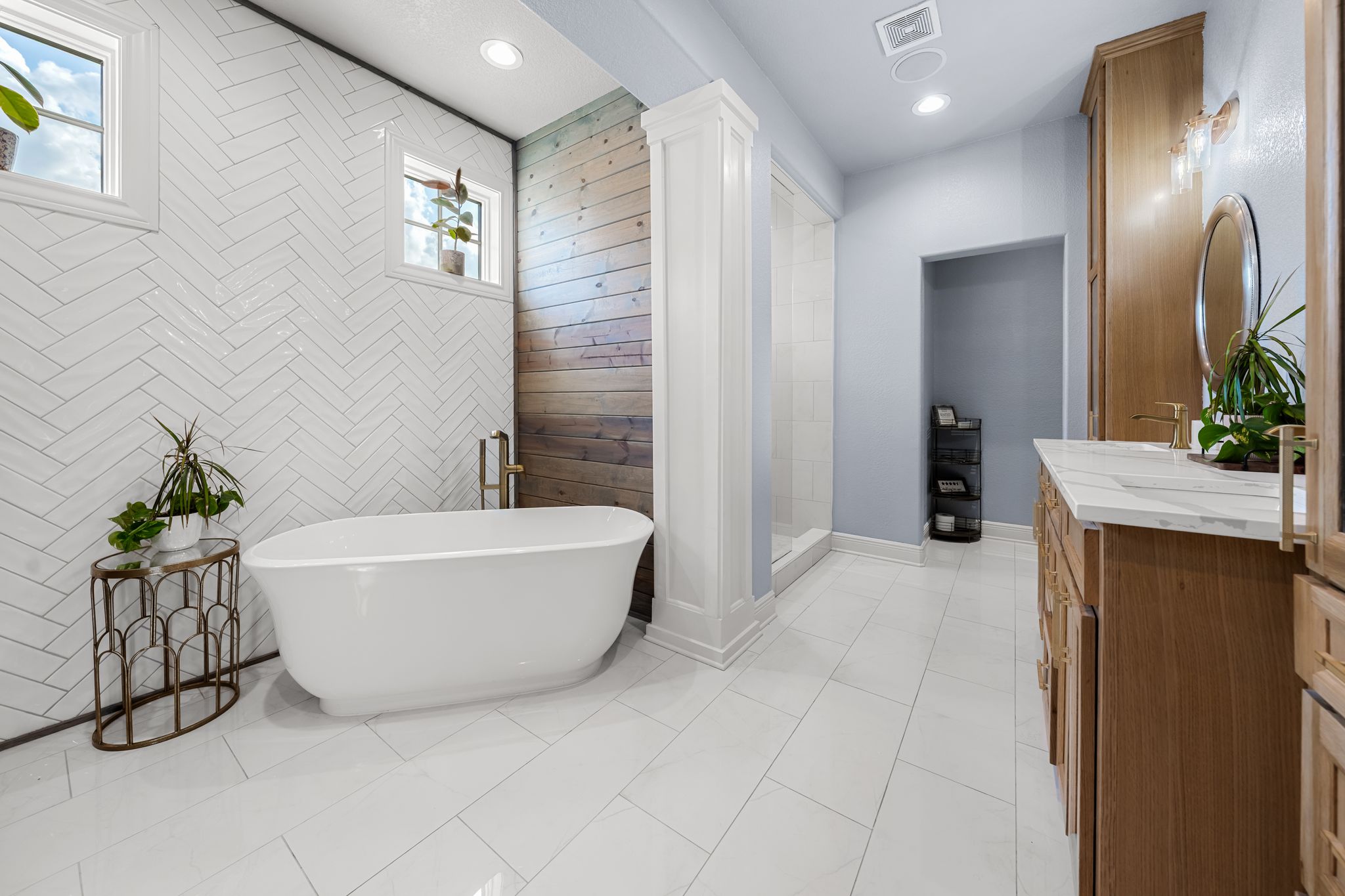 195 Desert Flower Spring Branch, TX 78070 - Photo 21 of 40 Freestanding soaking tub with a wall-mounted brass faucet, set against a herringbone tile wall with two windows