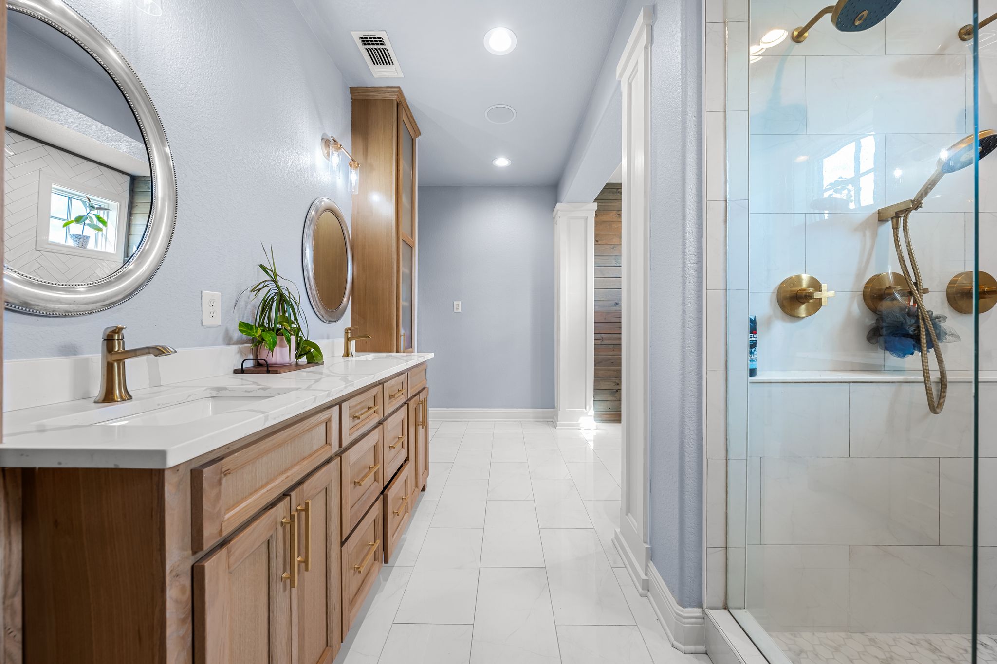 195 Desert Flower Spring Branch, TX 78070 - Photo 22 of 40 Spacious bathroom featuring a dual vanity with wood-finish cabinetry and gold-tone hardware, white countertops, and circular mirrors