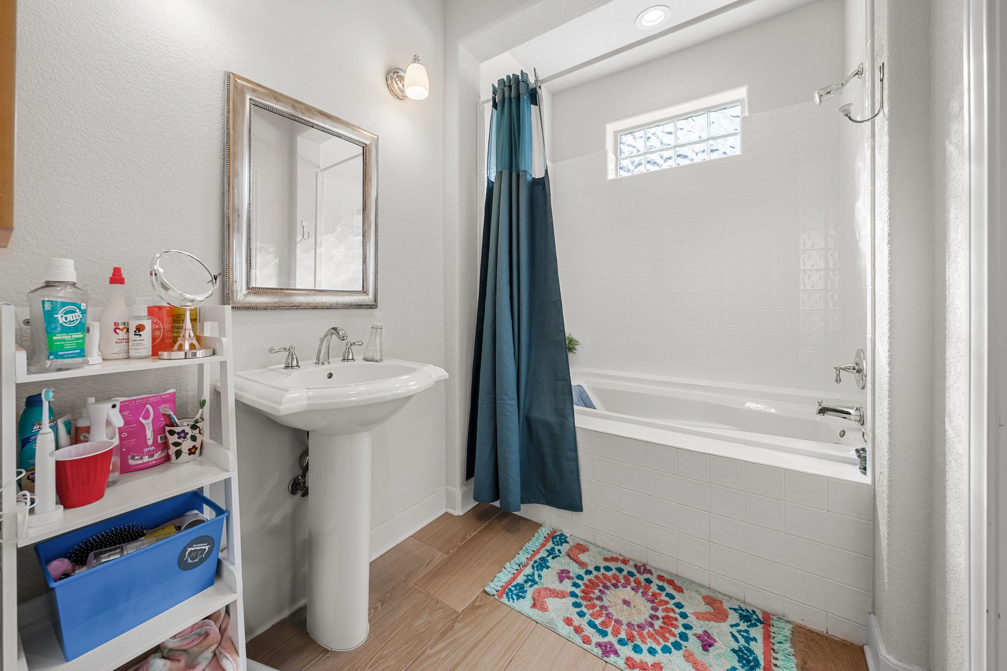 195 Desert Flower Spring Branch, TX 78070 - Photo 28 of 40 Bathroom featuring a pedestal sink, framed wall mirror, and a built-in bathtub with white tile surround