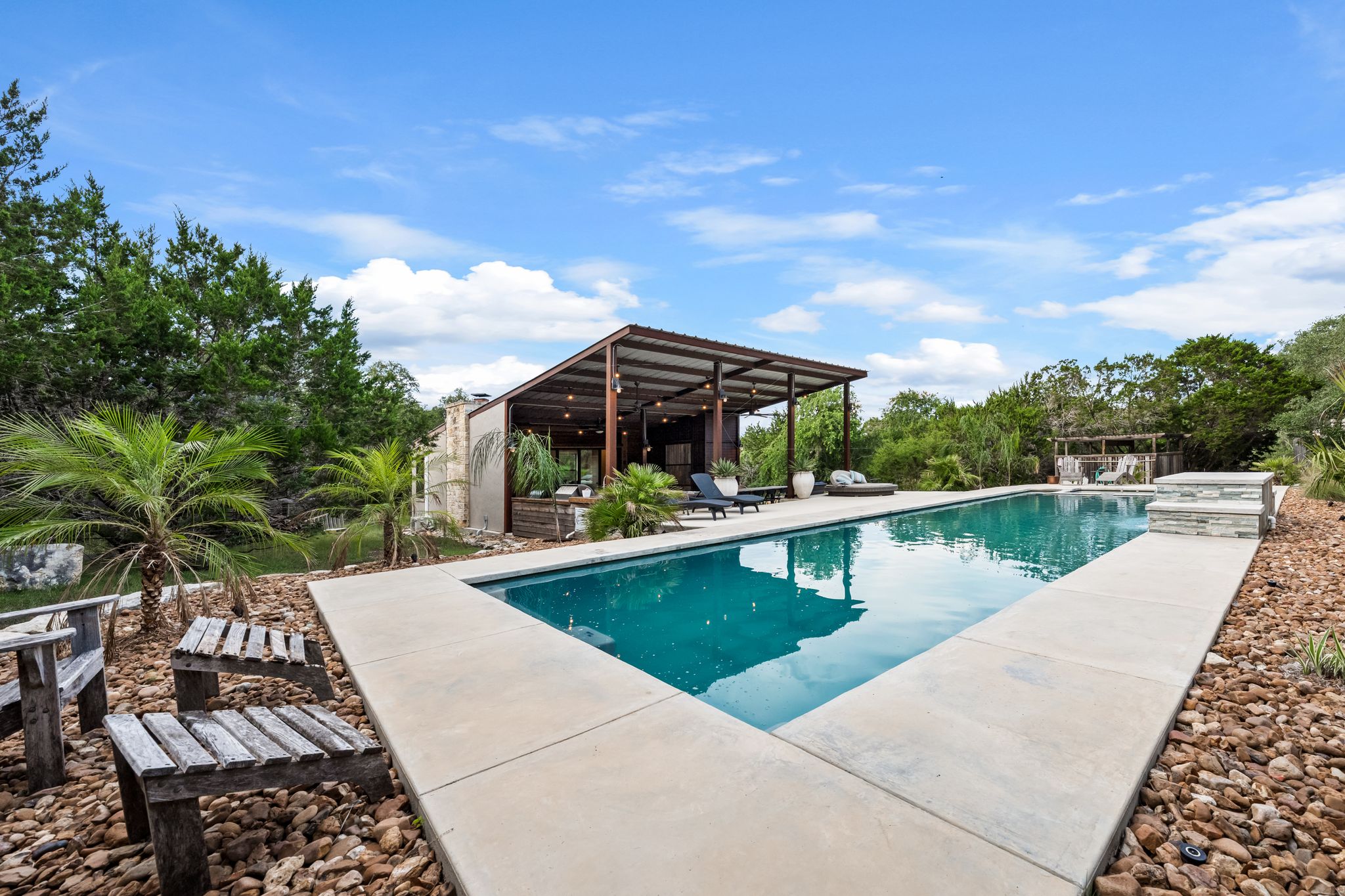 195 Desert Flower Spring Branch, TX 78070 - Photo 31 of 40 Rectangular swimming pool with concrete decking and a stone-clad water feature