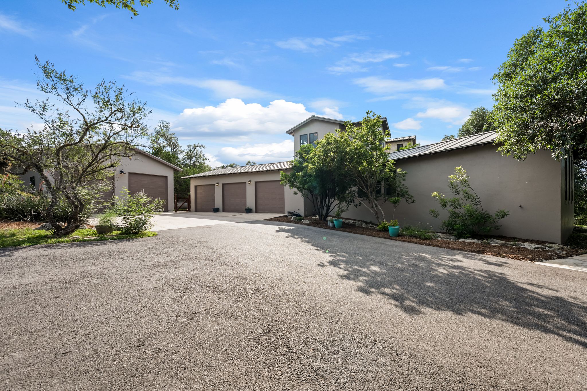 195 Desert Flower Spring Branch, TX 78070 - Photo 35 of 40 Expansive gravel driveway leading to a multi-car garage structure with four individual bays