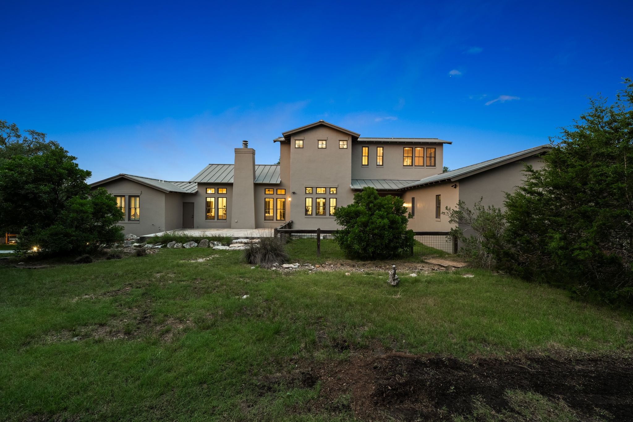 195 Desert Flower Spring Branch, TX 78070 - Photo 36 of 40 Multi-level stucco exterior featuring a metal roof and a prominent chimney