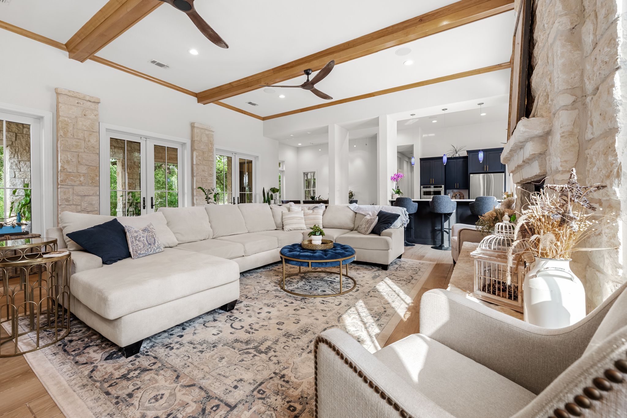 195 Desert Flower Spring Branch, TX 78070 - Photo 9 of 40 Open-concept living area featuring wood-finish flooring, exposed beam ceiling accents, and a floor-to-ceiling stone fireplace
