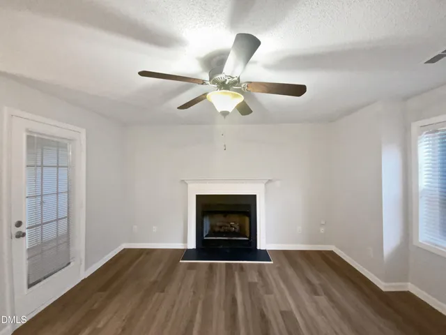 an empty room with fan and windows