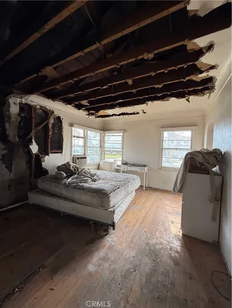 a view of a hallway with wooden floor and closet