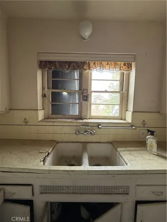 a kitchen with a sink a stove a refrigerator and wooden floor