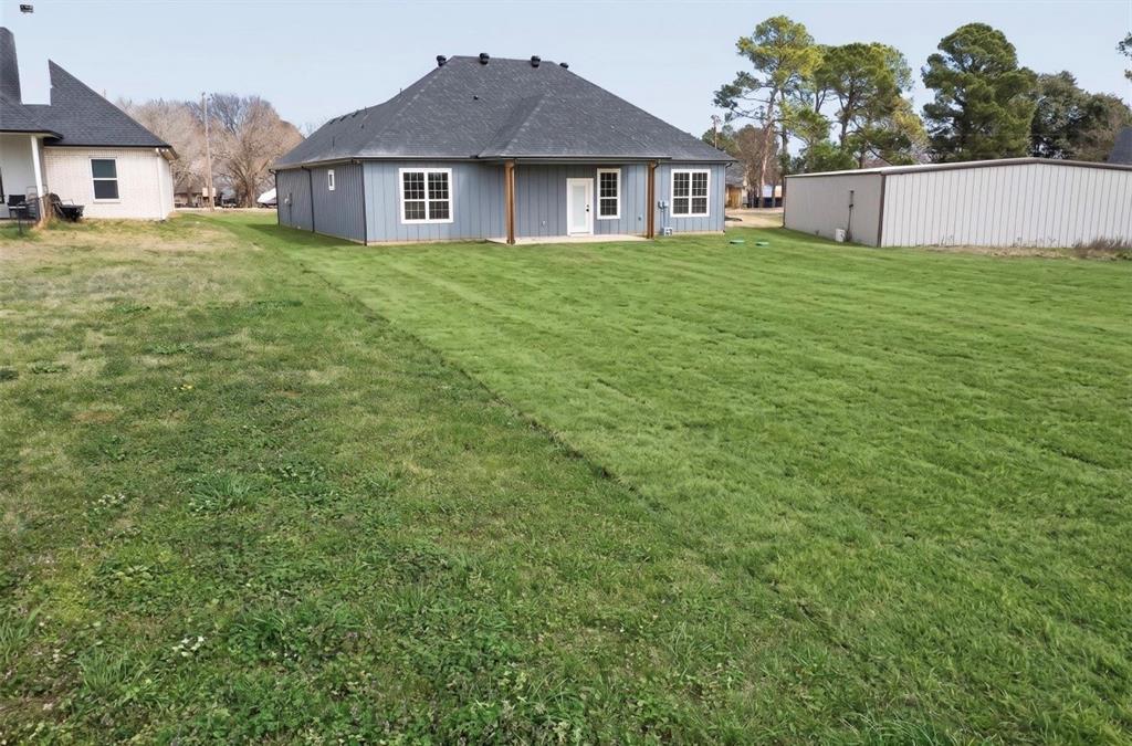 339 Cross Tie Ranch Road Trinidad, TX 75163 - Photo 27 of 29 Spacious rear yard with a well-maintained lawn and a blue-sided residence