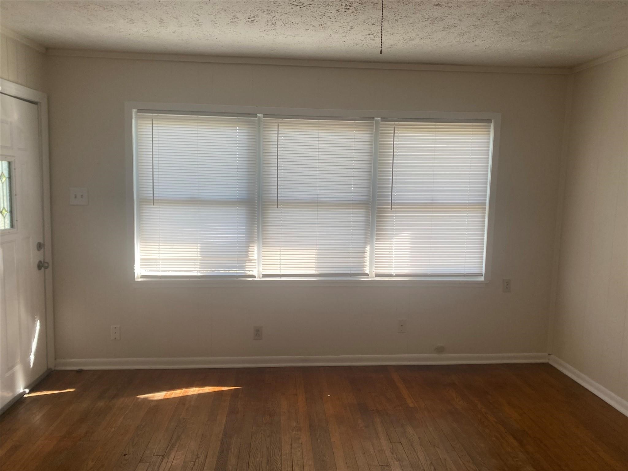 1021 Nottingham Drive Angleton, TX 77515 - Photo 4 of 8 an empty room with wooden floor and windows