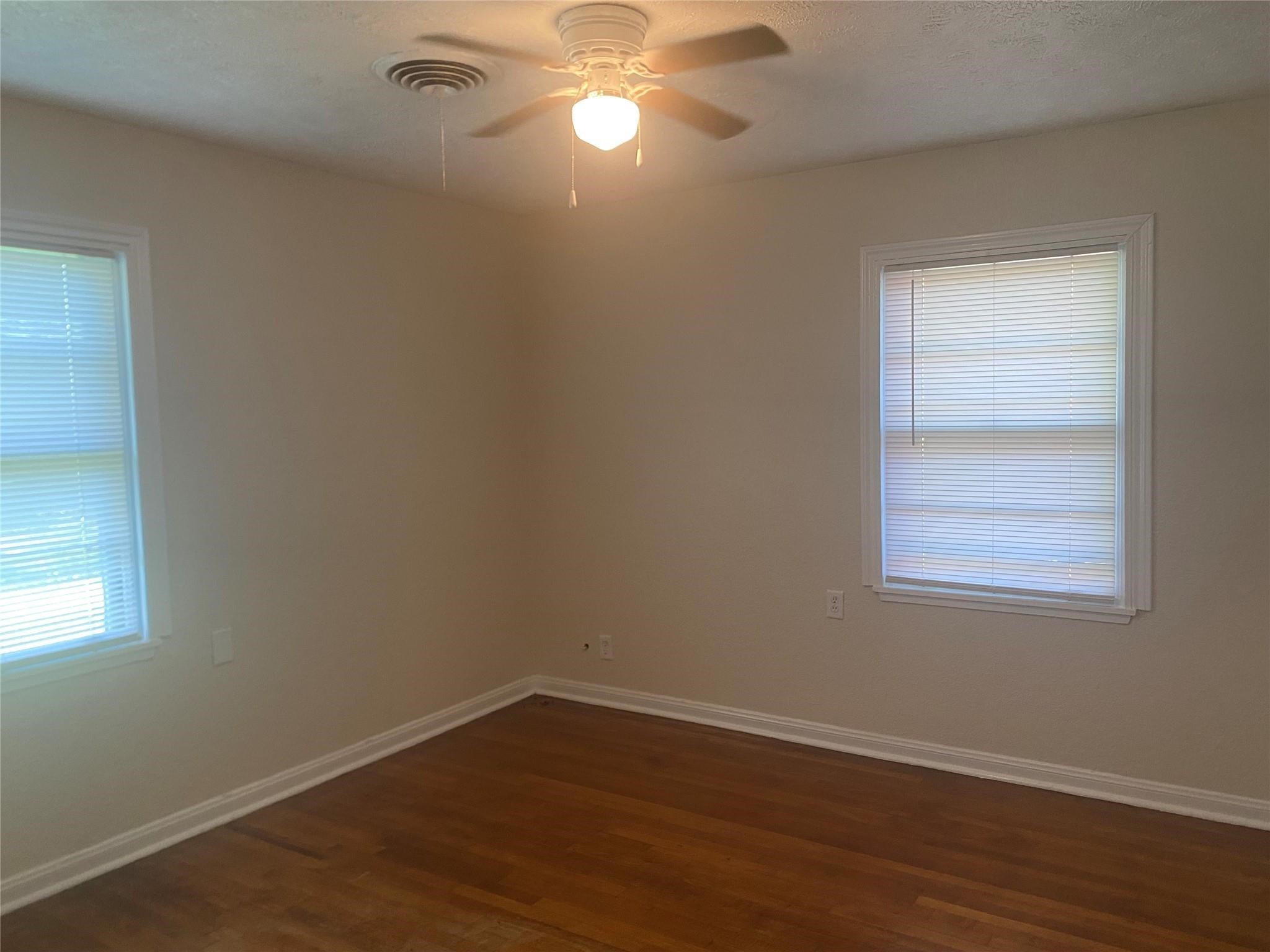 1021 Nottingham Drive Angleton, TX 77515 - Photo 6 of 8 a view of an empty room with wooden floor and a window