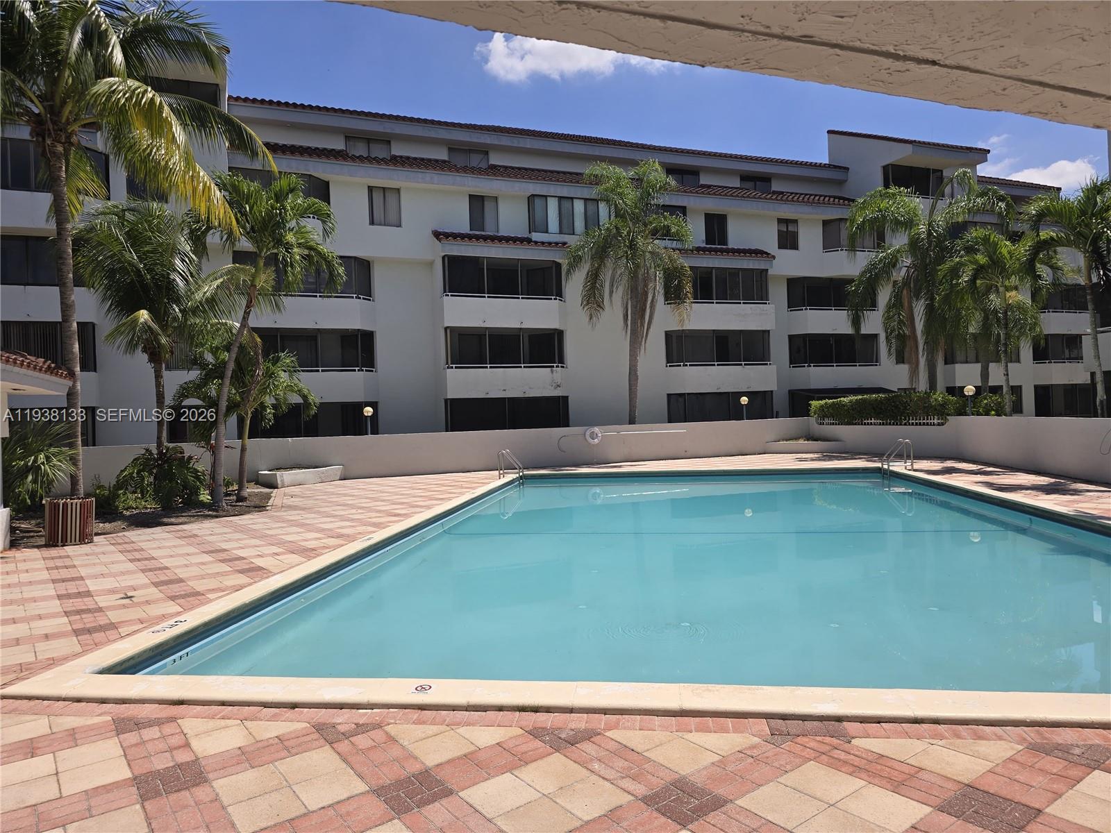 8255 Southwest 152nd Avenue, Unit E207 Miami, FL 33193 - Photo 2 of 14 a swimming pool with outdoor seating