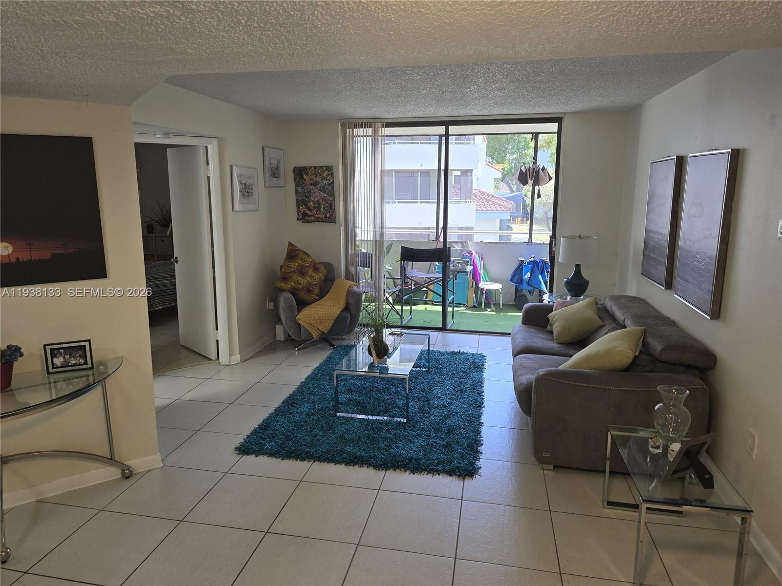 8255 Southwest 152nd Avenue, Unit E207 Miami, FL 33193 - Photo 3 of 14 a living room with couches and a flat screen tv