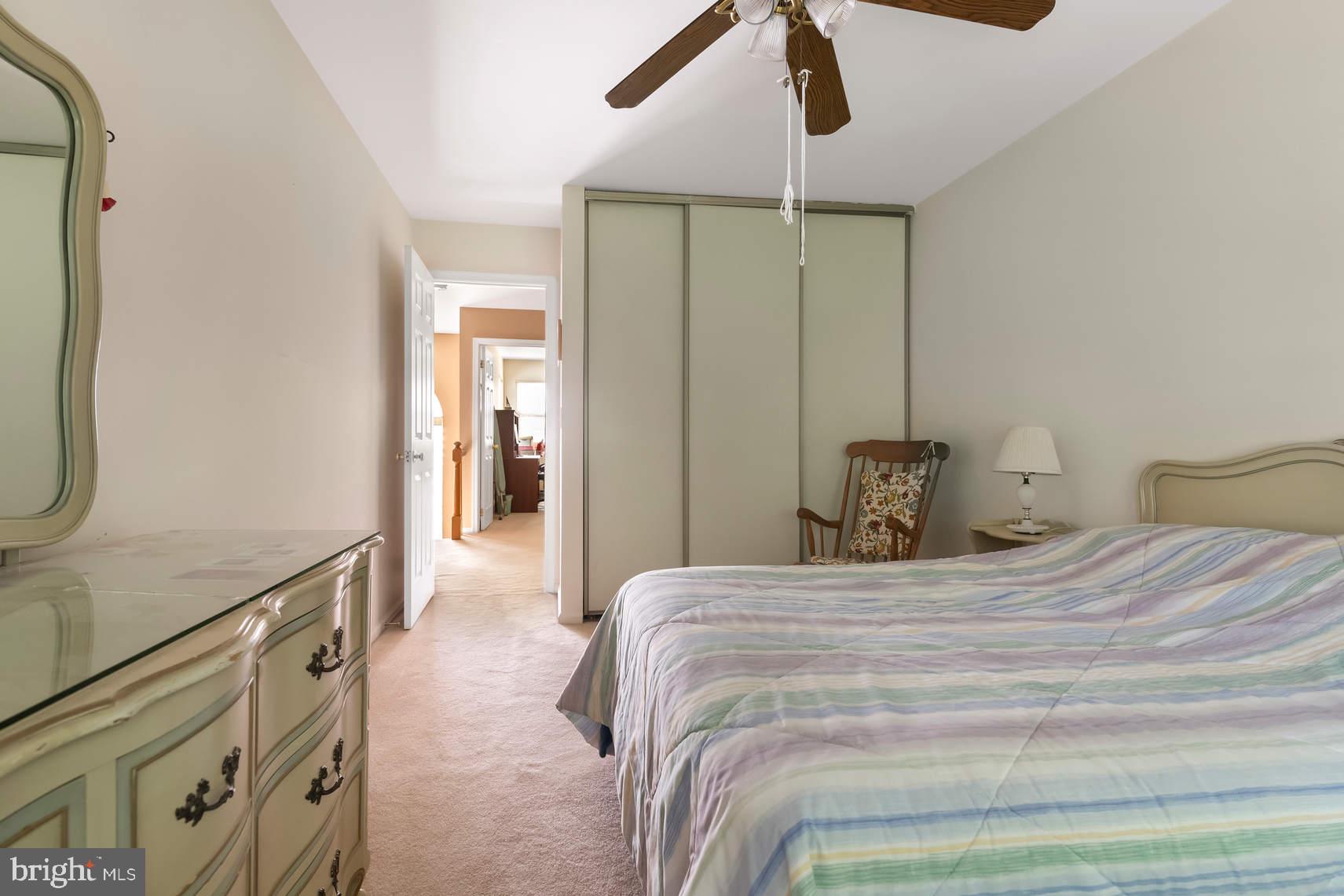 6 Spruce Road Hightstown, NJ 08520 - Photo 4 of 9 a bedroom with a bed a dresser and potted plants with the wooden floor