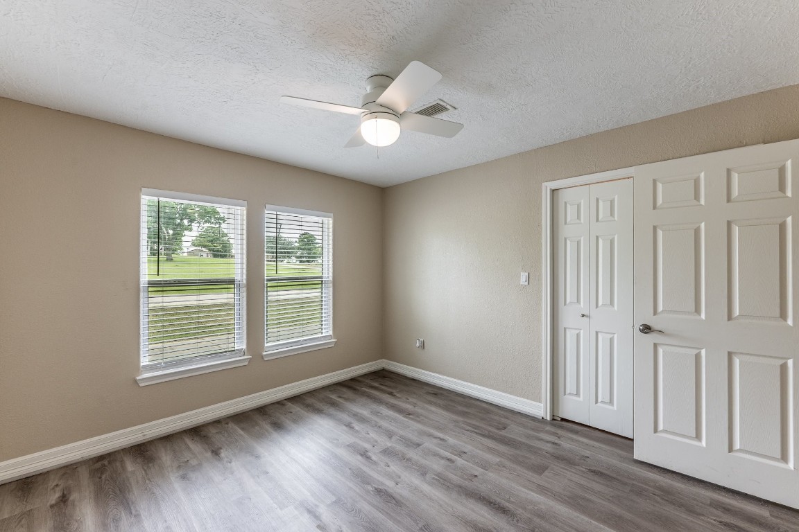 280 Crestmont Point Blank, TX 77364 - Photo 18 of 25 an empty room with wooden floor chandelier fan and windows