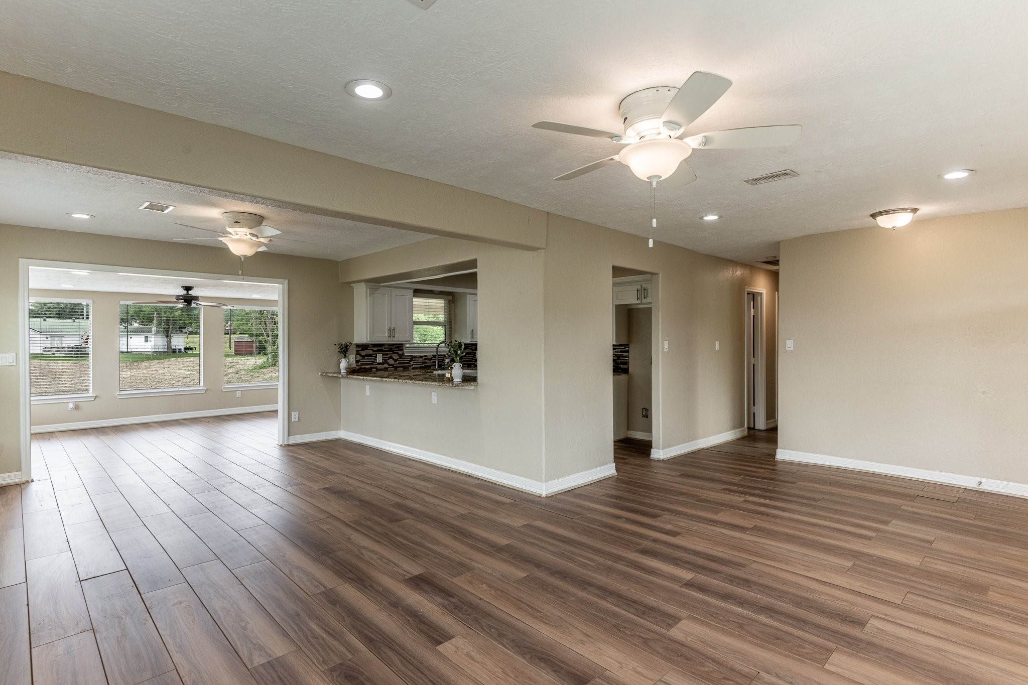 280 Crestmont Point Blank, TX 77364 - Photo 3 of 25 a view of an empty room and kitchen with wooden floor