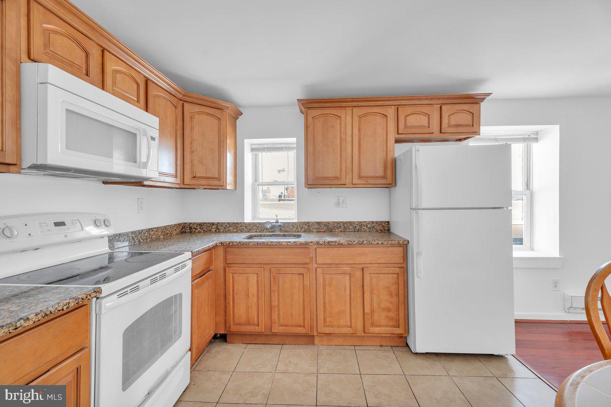 3151 Richmond Street, Unit 3 Philadelphia, PA 19134 - Photo 11 of 22 a kitchen with stainless steel appliances granite countertop a refrigerator and a stove top oven