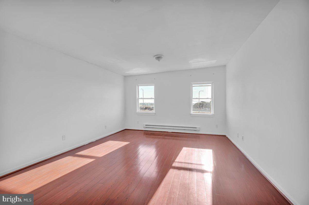 3151 Richmond Street, Unit 3 Philadelphia, PA 19134 - Photo 14 of 22 an empty room with wooden floor and windows