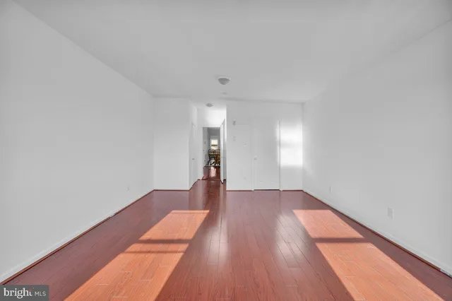 a view of empty room with wooden floor