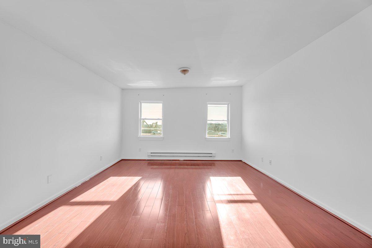 3151 Richmond Street, Unit 3 Philadelphia, PA 19134 - Photo 17 of 22 an empty room with wooden floor and windows