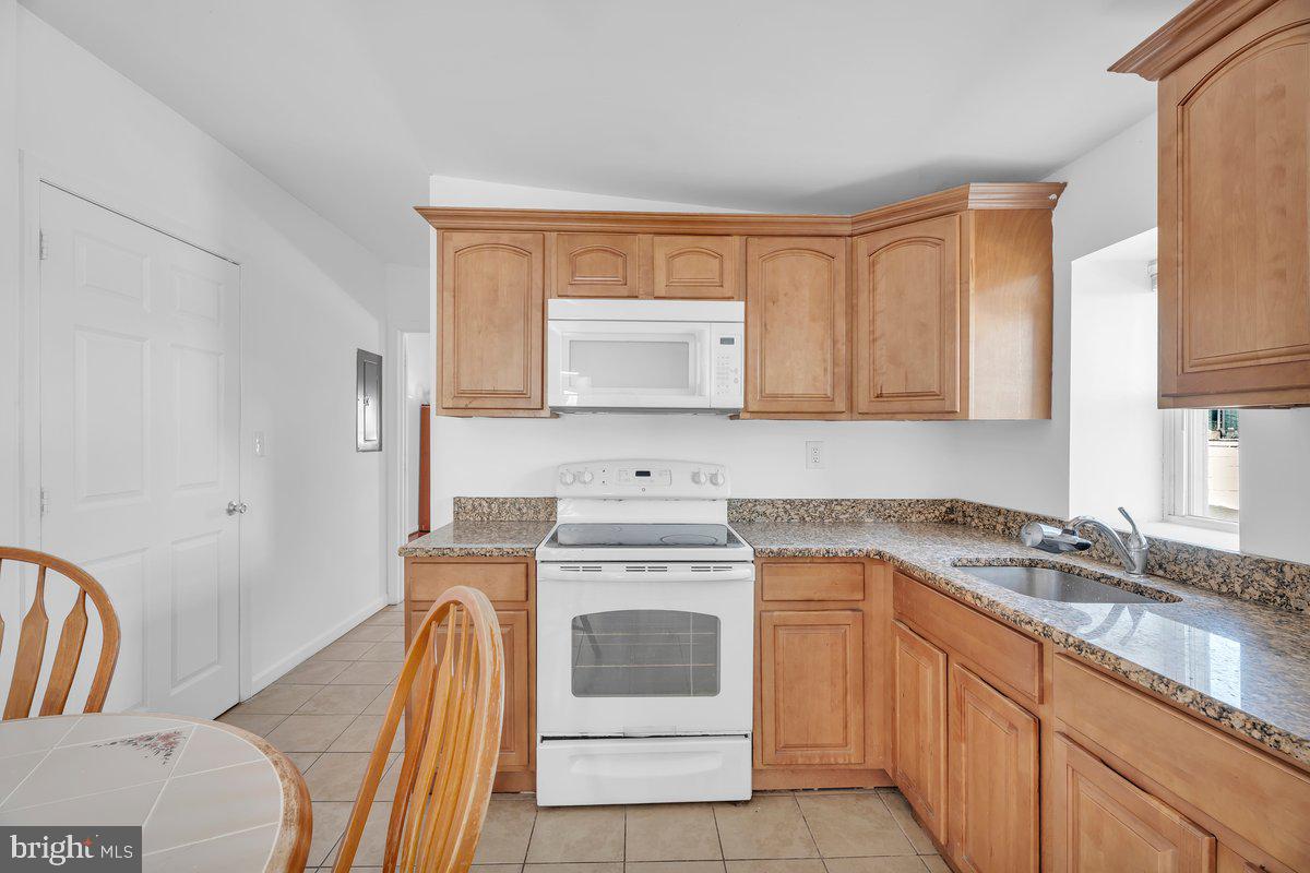 3151 Richmond Street, Unit 3 Philadelphia, PA 19134 - Photo 8 of 22 a kitchen with granite countertop a sink stove and cabinets