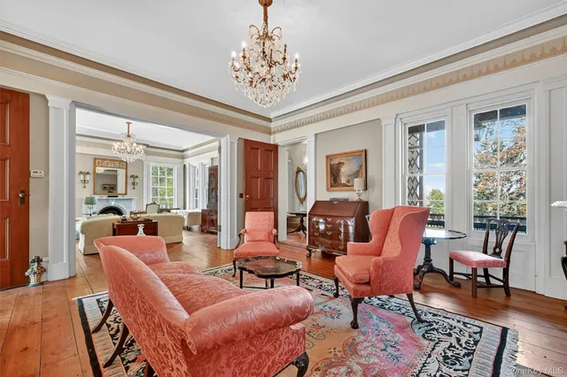 a living room with furniture a chandelier and a rug