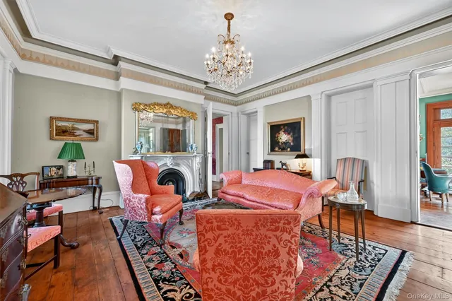 a living room with furniture a chandelier and a fireplace