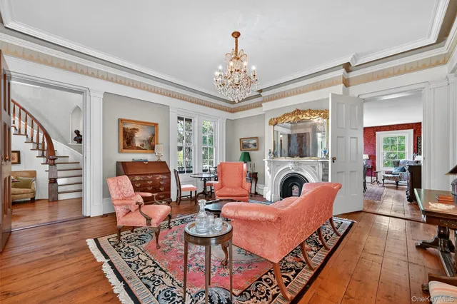 a living room with furniture a fireplace and a chandelier