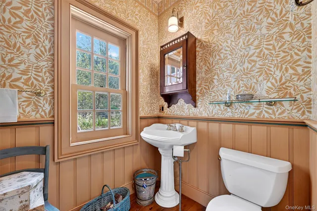 a bathroom with a toilet sink and mirror