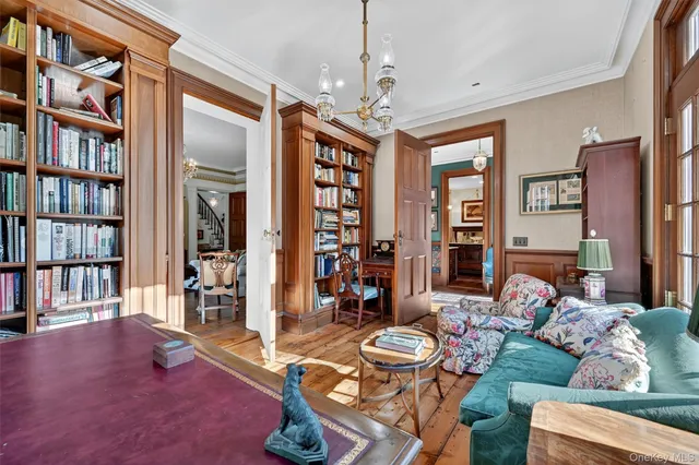 a living room with furniture a bookshelf and a window