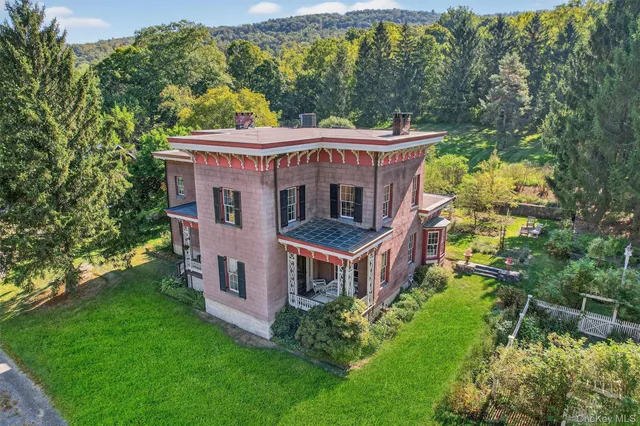 a view of a house with a big yard plants and large trees