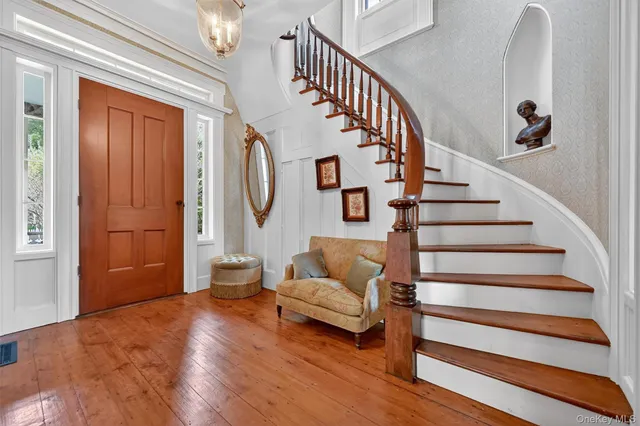 a view of entryway and hall with wooden floor